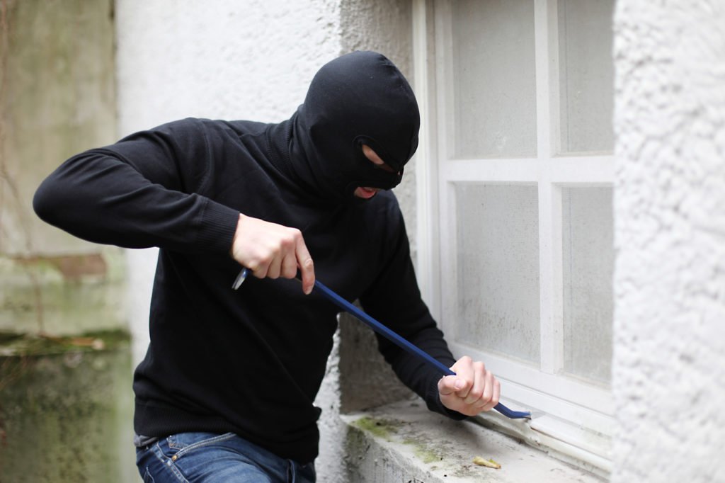 Einbrecher am Kellerfenster Smartguards Ferienüberwachung Berlin